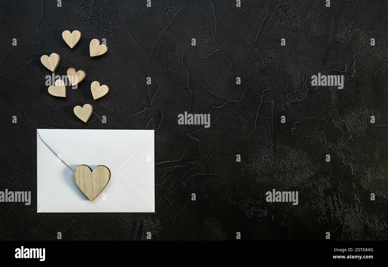 Valentinstag romantisches Konzept. Holzherzen und umhüllen auf schwarzem Hintergrund. Stockfoto