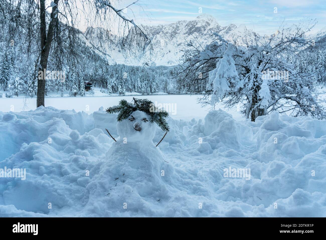 Ein Schneemann am Ufer des Fusine Sees, Tarvisio, gefroren im Winter Stockfoto