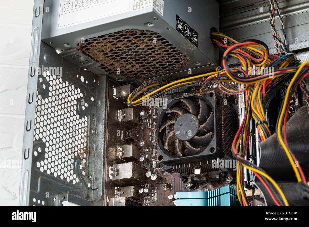 Im Inneren des Tower-Computergehäuses mit staubigen defekten Netzteilen vor dem Austausch durch ein neues. Ersatz des PC-Netzteils, Hardware. Stockfoto