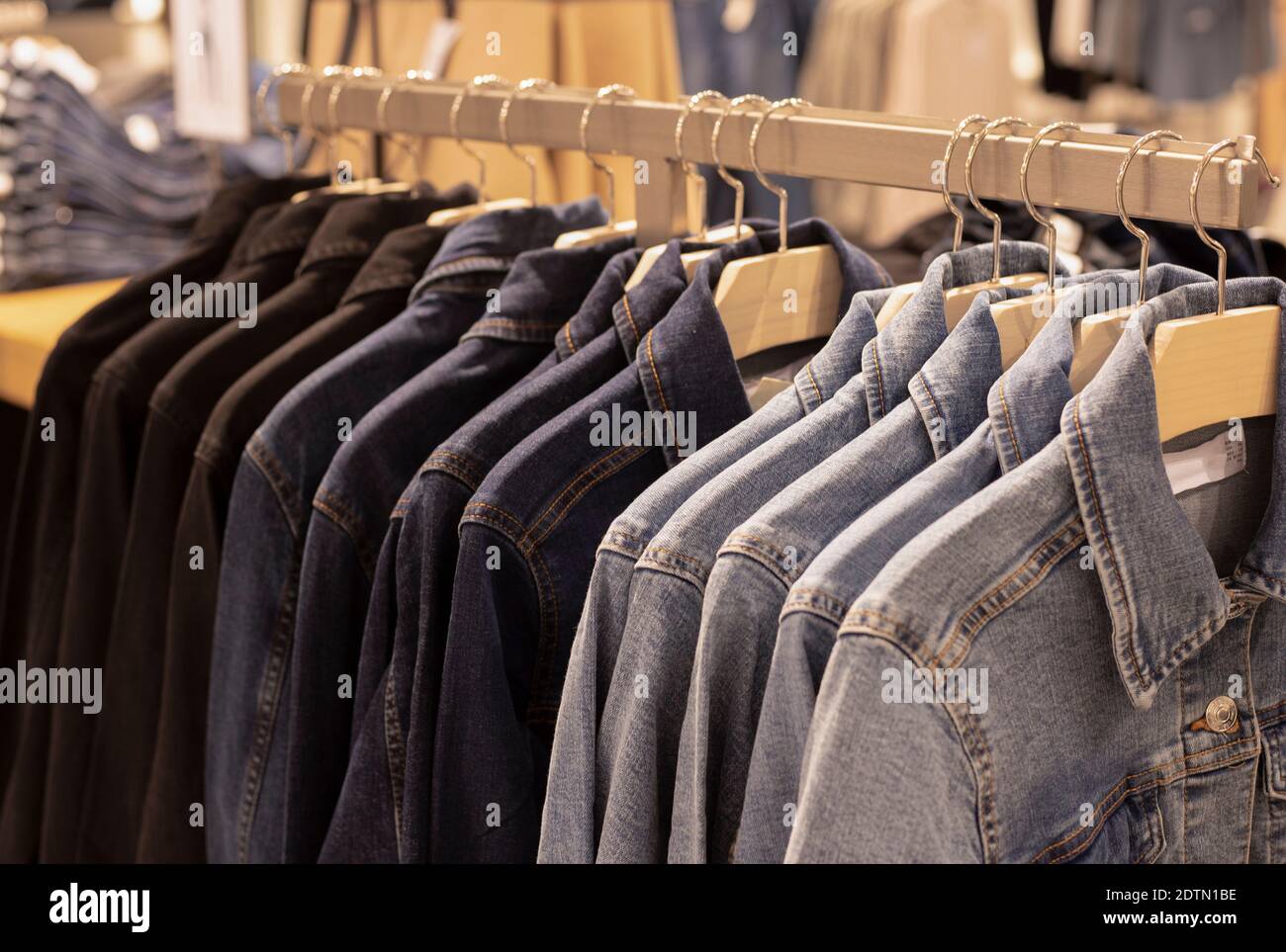 Damenbekleidung - Herbst Winter Kollektion. Denim Jacken auf Kleiderbügeln im Laden. Das Konzept des bewussten Verbrauchs und Recycling der Dinge. Stockfoto