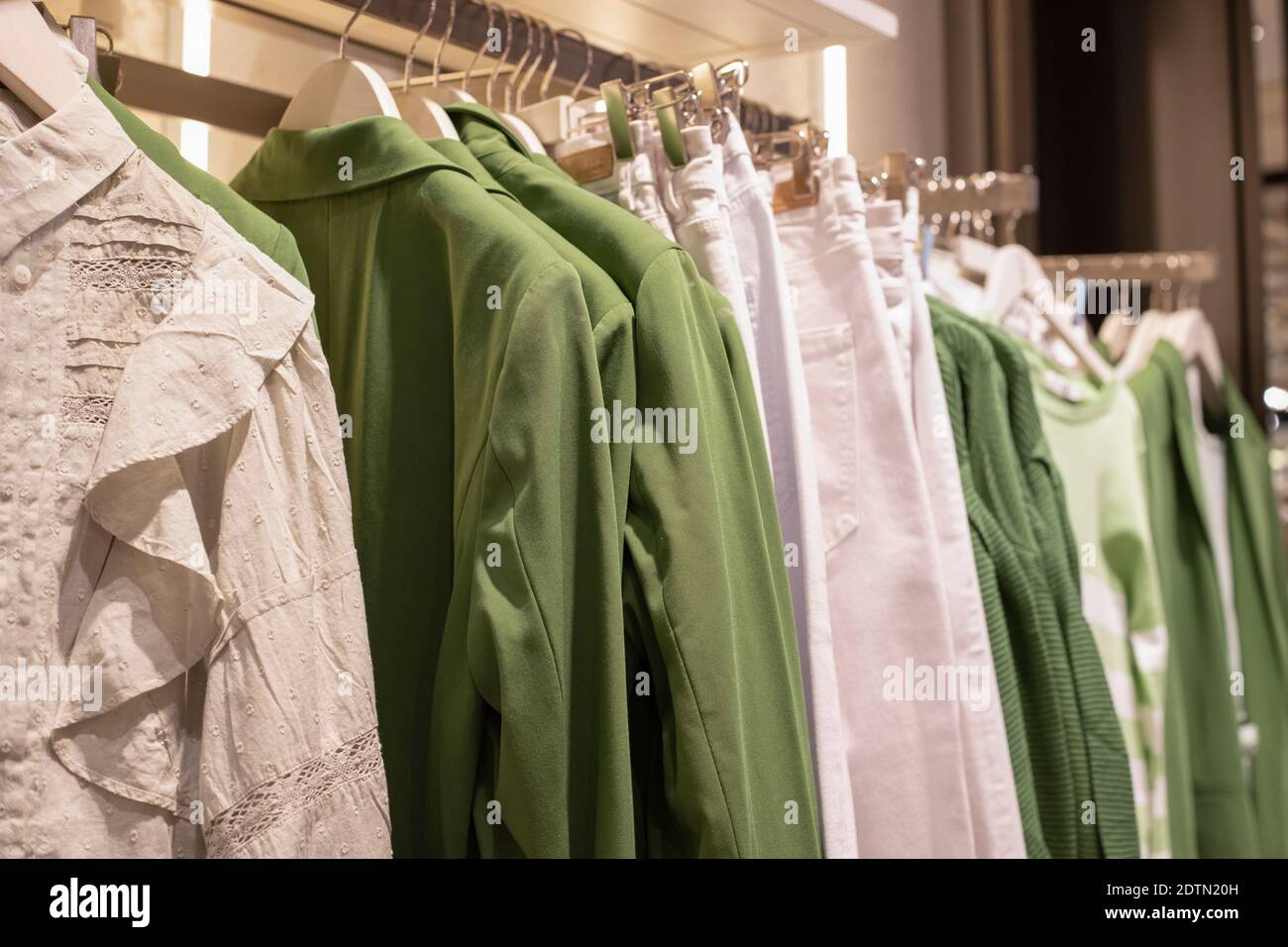 Damenbekleidungskollektion auf Kleiderbügeln im Laden. Das Konzept des bewussten Konsums und Recycling von Dingen. Stockfoto