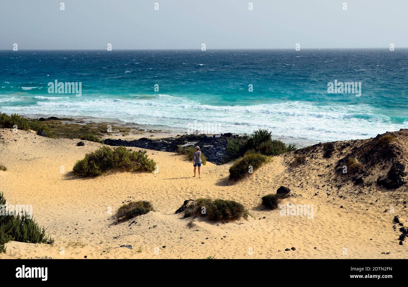 Spanien, Kanarische Inseln, Fuerteventura, Frau beim Strandspaziergängen in Playa de Corralejo Stockfoto