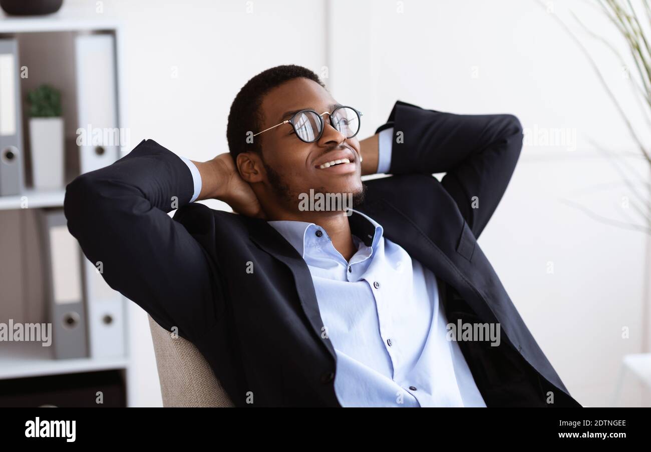 Nahaufnahme eines entspannten schwarzen Geschäftsmannes, der eine Brille im Büro trägt Stockfoto