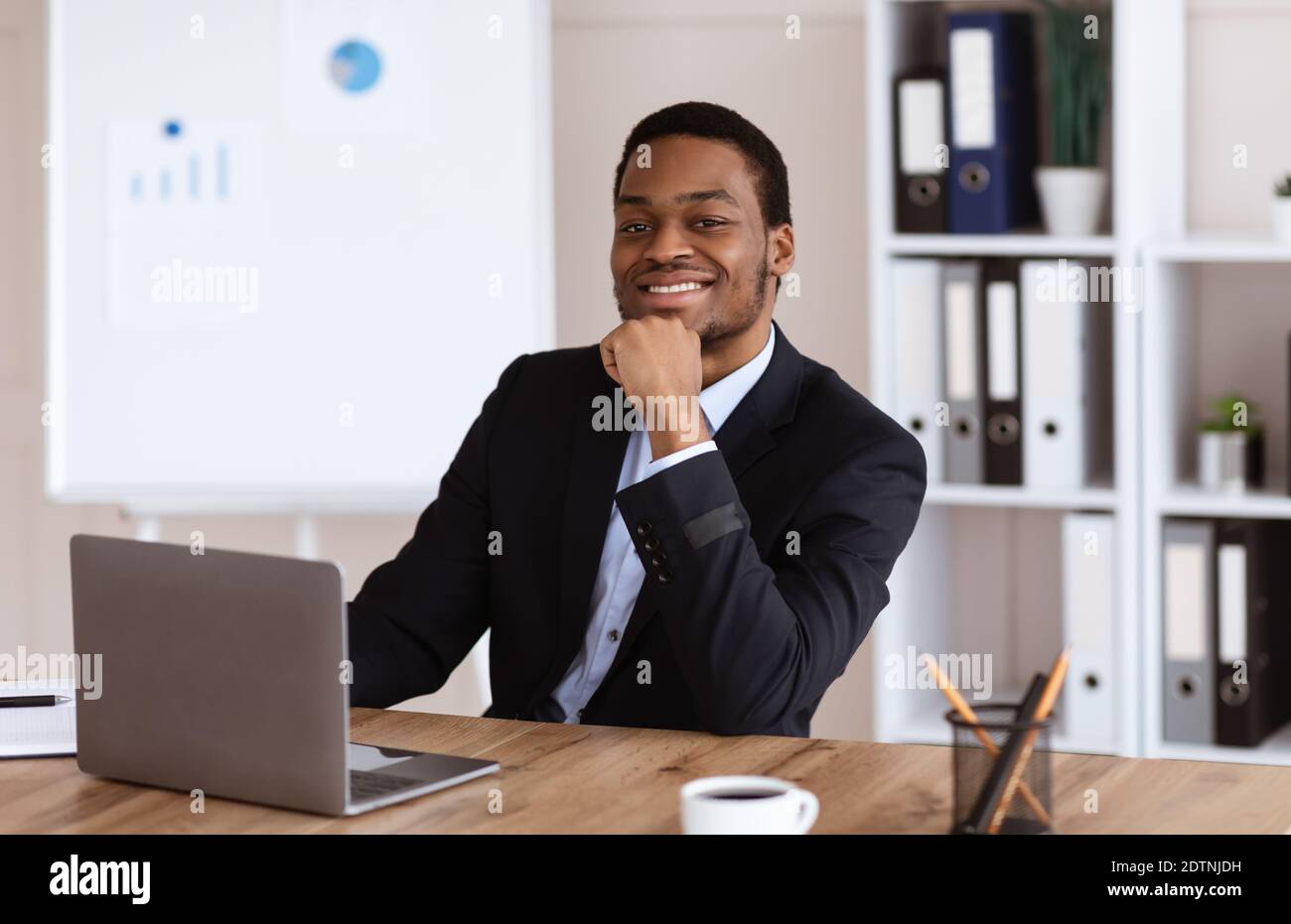 Erfolgreicher afroamerikanischer Geschäftsmann sitzt in seinem Büro Stockfoto
