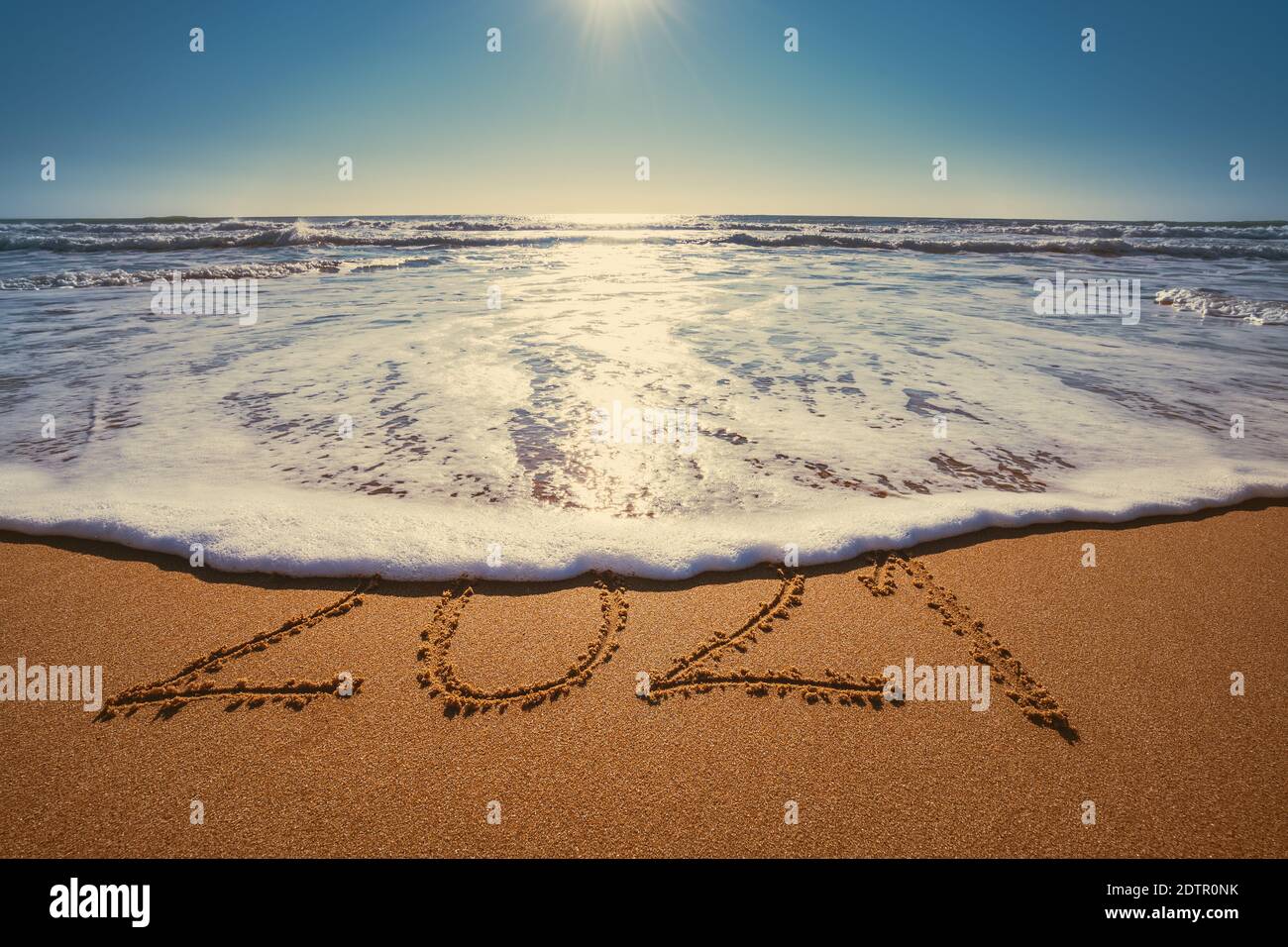 Happy New Year 2021 Konzept, Schriftzug am Strand. Geschriebener Text am Strand bei Sonnenaufgang. Stockfoto