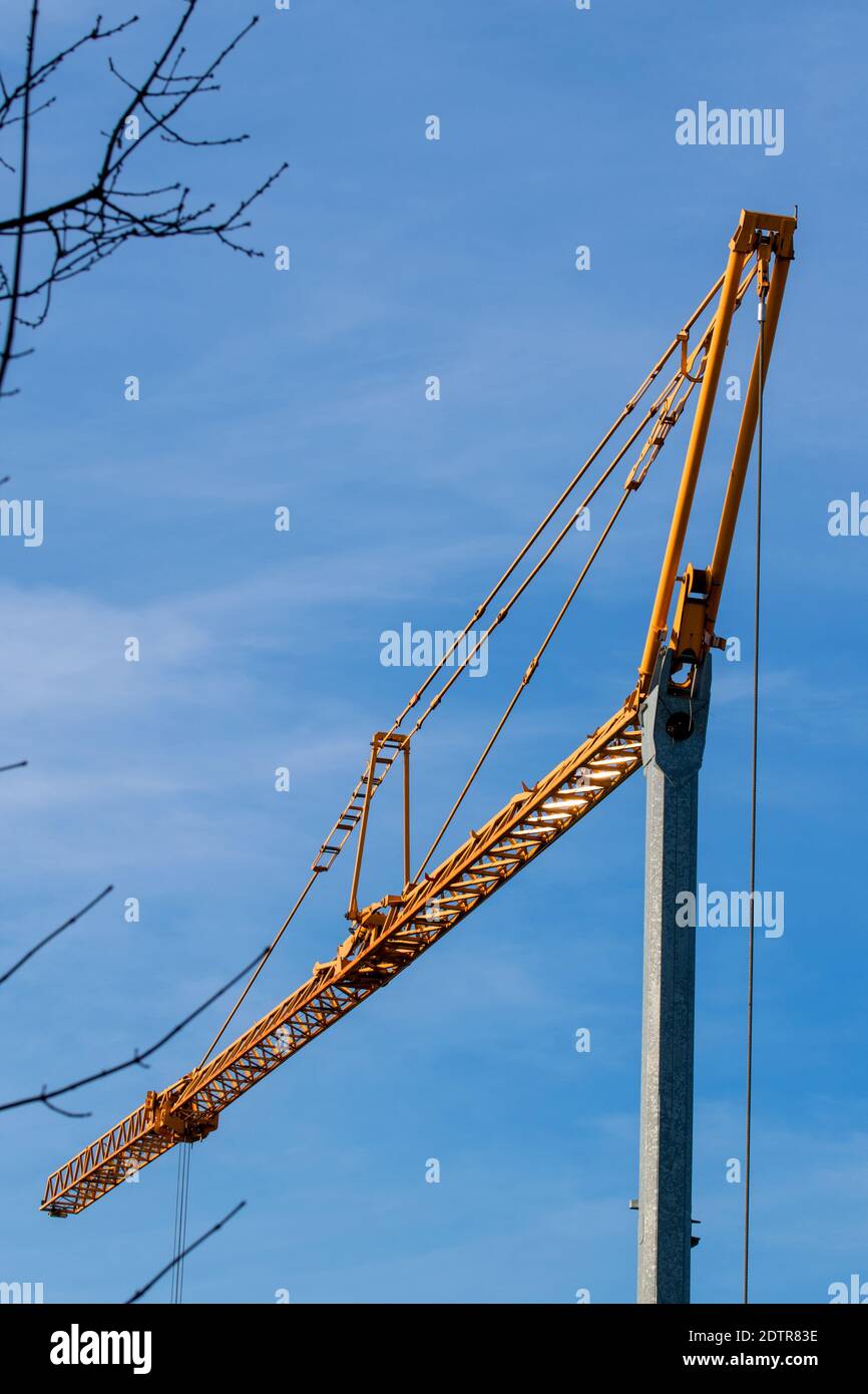 Kran mit gelbem Boom gegen einen blauen Himmel Stockfoto