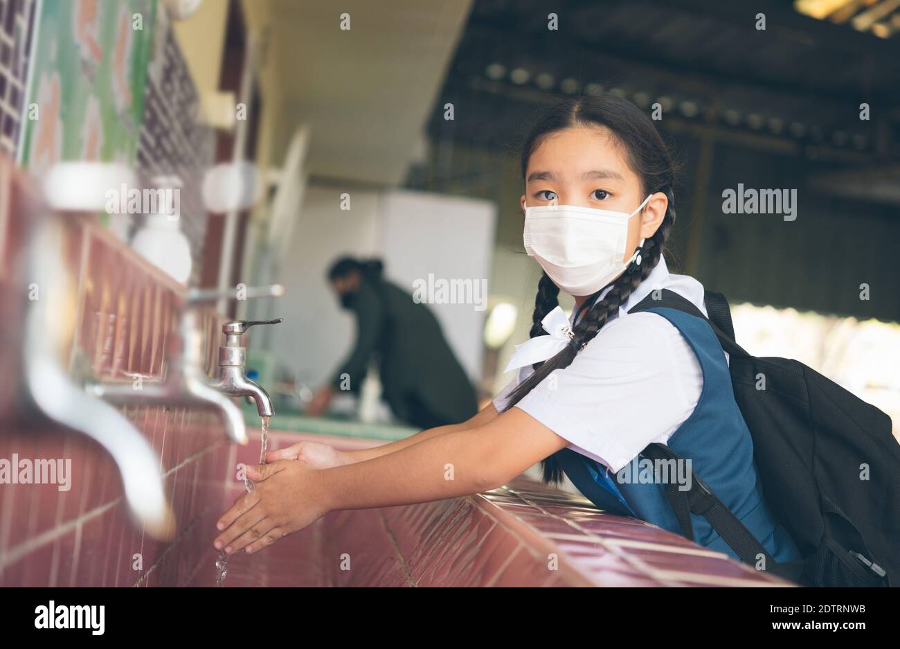 Asiatischer Schüler, der sich am Außenwaschbecken der Schule die Hände wascht. Prävention ansteckender Krankheiten, Pest. Gesundheit der Kinder, Schutz des Virus Covid - Stockfoto