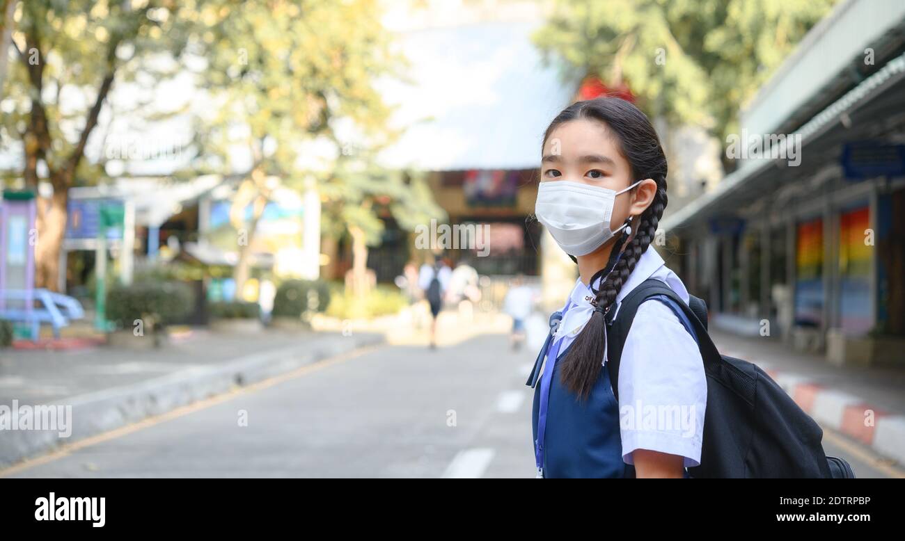 Zurück zur Schule. asiatische Kind Mädchen trägt Gesichtsmaske mit Rucksack zur Schule gehen.Covid-19 Coronavirus pandemic.New normalen Lebensstil.Education Konzept Stockfoto