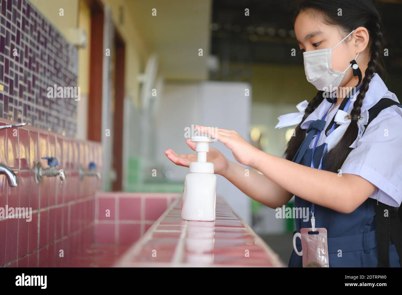 Asiatische Kind Mädchen Schüler waschen Hände und Masken tragen in der Schule. Schule aus der Sperre wieder öffnen. Covid-19 Coronavirus-Pandemie. Neue Normalität in der Schule. Stockfoto