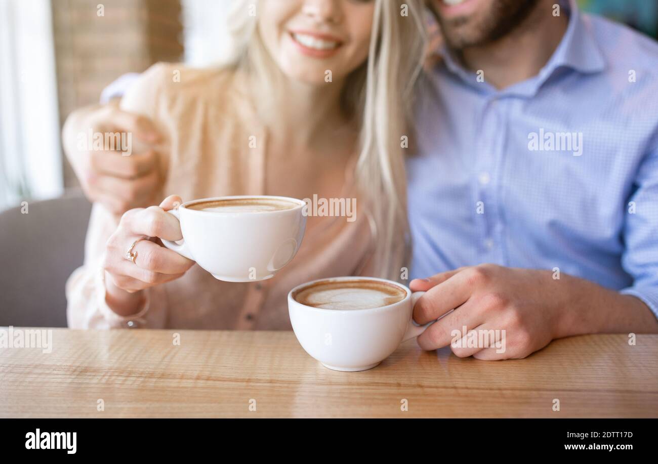Kurzer Blick auf ein romantisches Paar, das Kaffee trinkt und sich umarmt Café Stockfoto