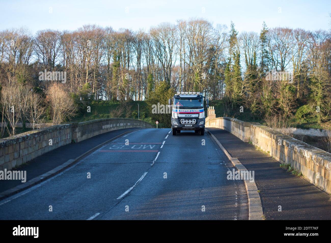 Schottische/englische Grenze, Coldstream, Schottland, Großbritannien. Dezember 2020. Im Bild: Eine sehr ruhige Straße, die Schottland mit dem Norden Englands in der Grenzstadt Coldstream mit der steinernen Bogenbrücke über den Fluss Tweed verbindet. Der schottische erste Minister Nicola Sturgeon hatte grenzüberschreitende Reisen verboten, um die Ausbreitung des neuen Coronavirus-Stammes (COVID19) zu stoppen. Es gibt eine kleine Polizeipräsenz, aber der Verkehr ist frei fließend und leicht. Quelle: Colin Fisher/Alamy Live News Stockfoto