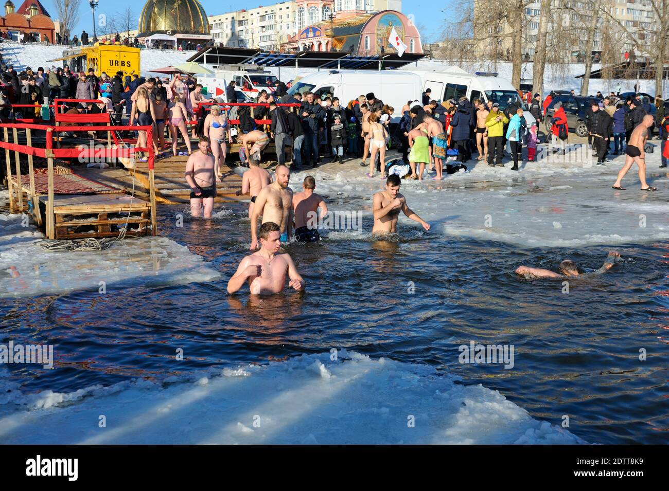 Menschen schwimmen in einem Eisloch während des Dreikönigsfestes auf dem Fluss Dnjepr, Sviato-Pokrovskiy Kathedrale auf einem Hintergrund. Januar 19, 2019. Kiew, Ukr Stockfoto