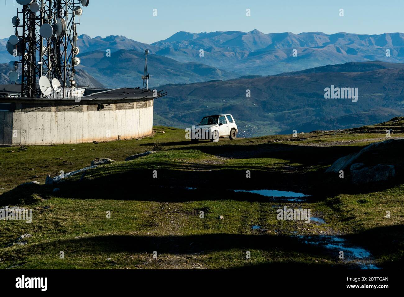 Geländewagen auf der Spitze der Berge mit Ein Luftanbau auf seiner Seite und ein schlammiger Boden Stockfoto