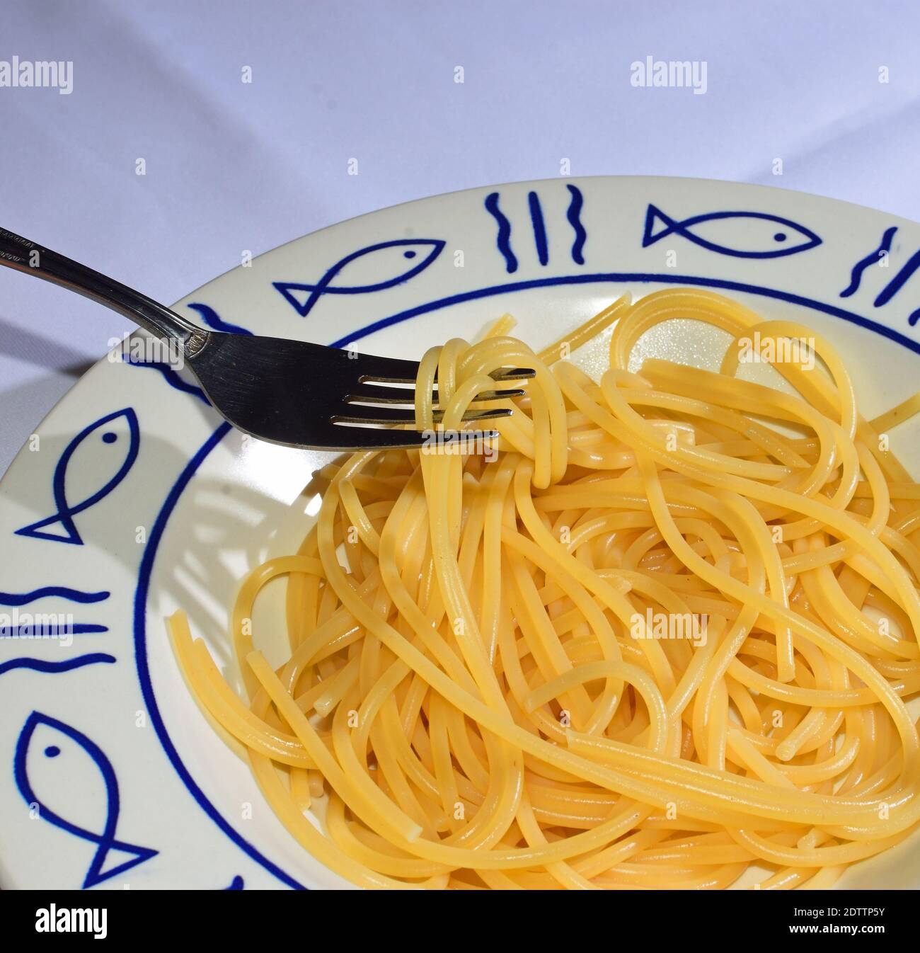 Spaghetti mit Folk auf Teller mit Fisch-Design. Stockfoto