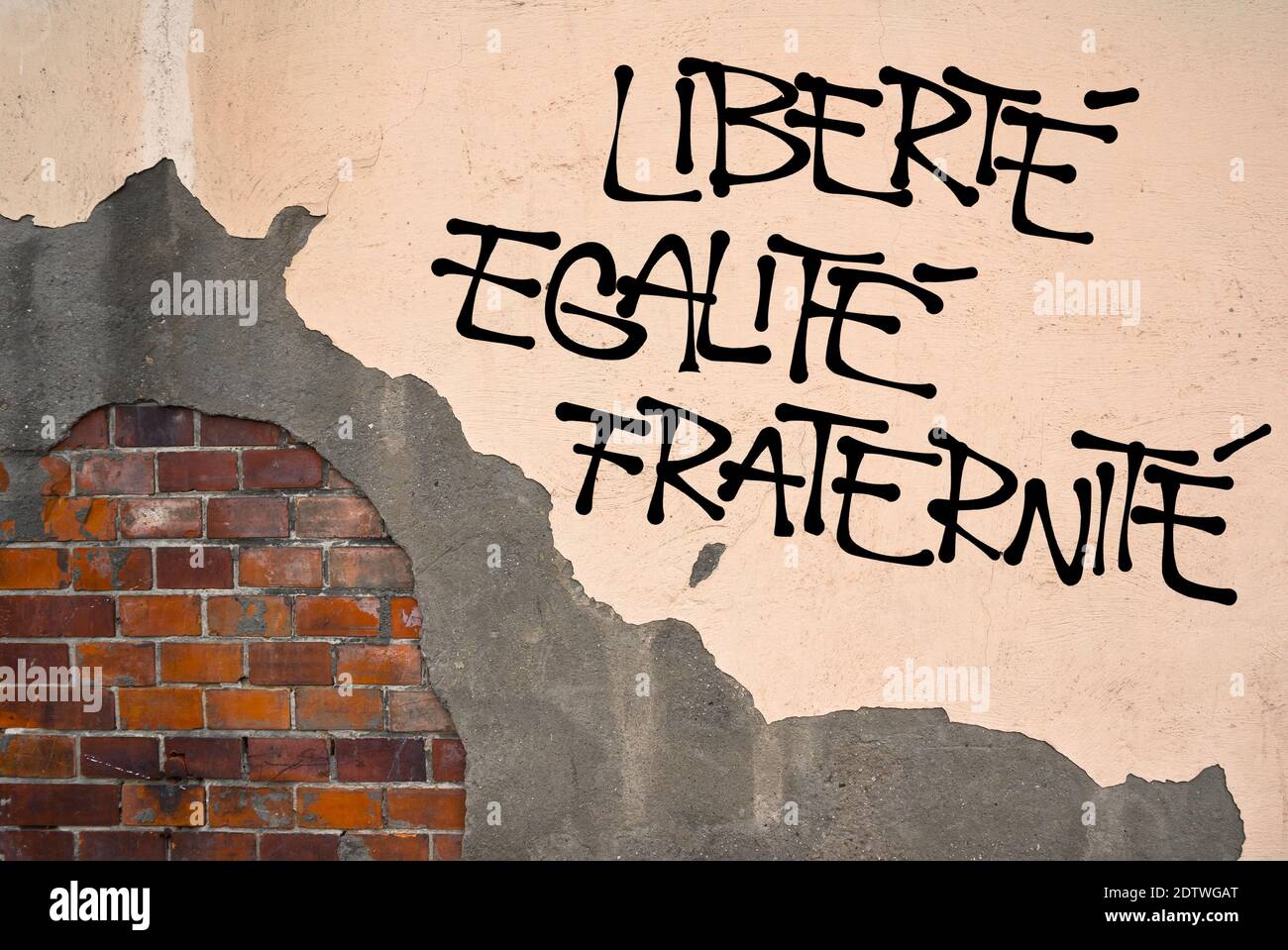 Französischer Text Liberte, Egalite, Fraternite ( Freiheit, Gleichheit, Brüderlichkeit ) - handgeschriebene Graffiti an der Wand, anarchistische Ästhetik. Revolutionär mot Stockfoto