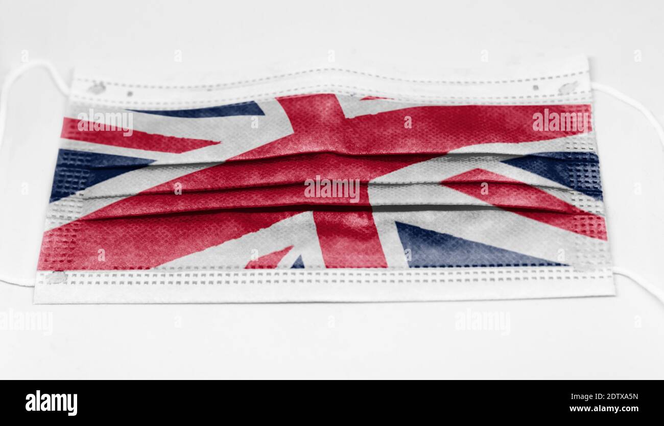 Chirurgische Maske mit der Nationalflagge Englands gedruckt. Pandemie covid-19 und vorbeugende Maßnahmen zur Bekämpfung der Ausbreitung des Virus Stockfoto