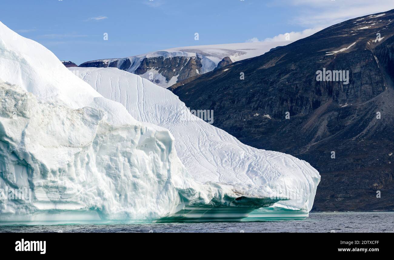 Eisberg im Uummannaq Fjord System. Vergletscherte Halbinsel Nuussuaq im Hintergrund. Amerika, Nordamerika, Grönland, Dänemark Stockfoto