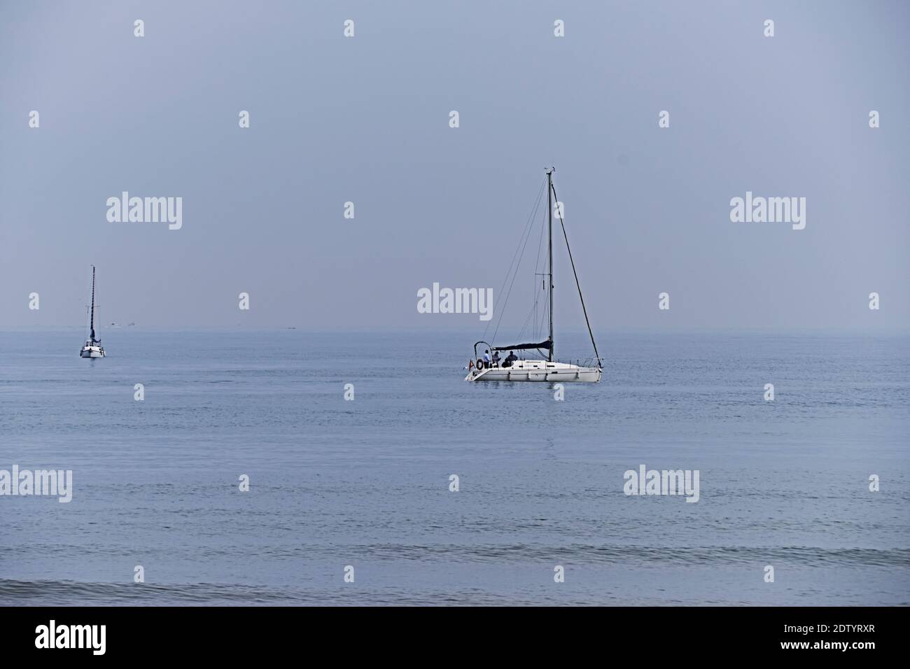 Zwei Segelboote segeln in ruhigen Gewässern, Gruppe, Meer, Meer, kein Kontrast Stockfoto