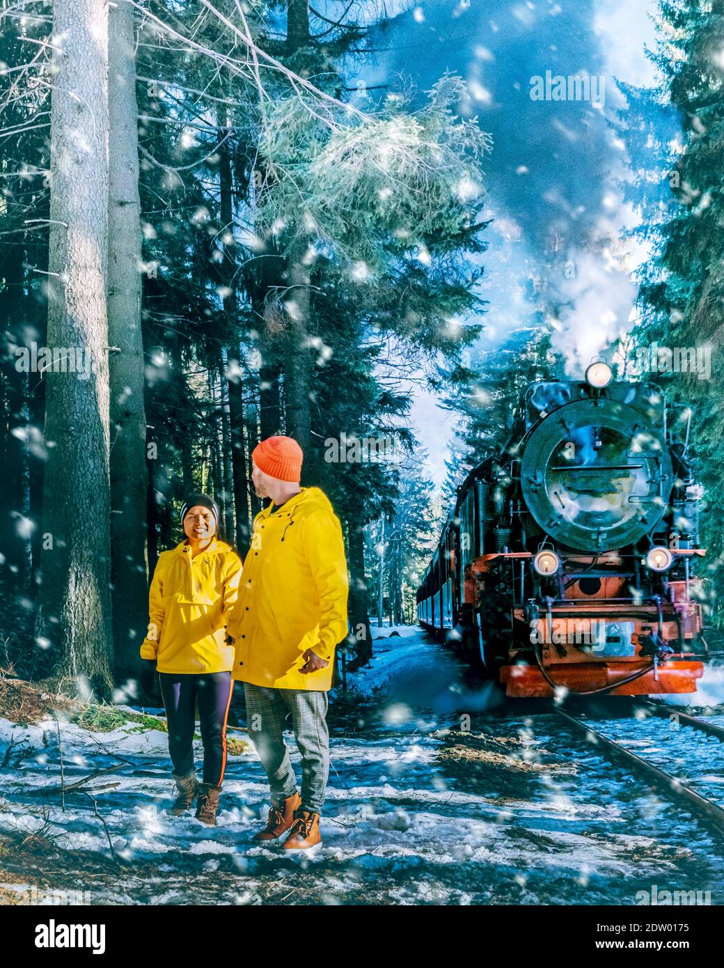 Paar Männer und Frauen wandern im Harz Nationalpark Deutschland, Dampfzug auf dem Weg nach Brocken durch die Winterlandschaft, berühmte Dampfzug durch den Winterberg. Brocken, Harz Deutschland Stockfoto