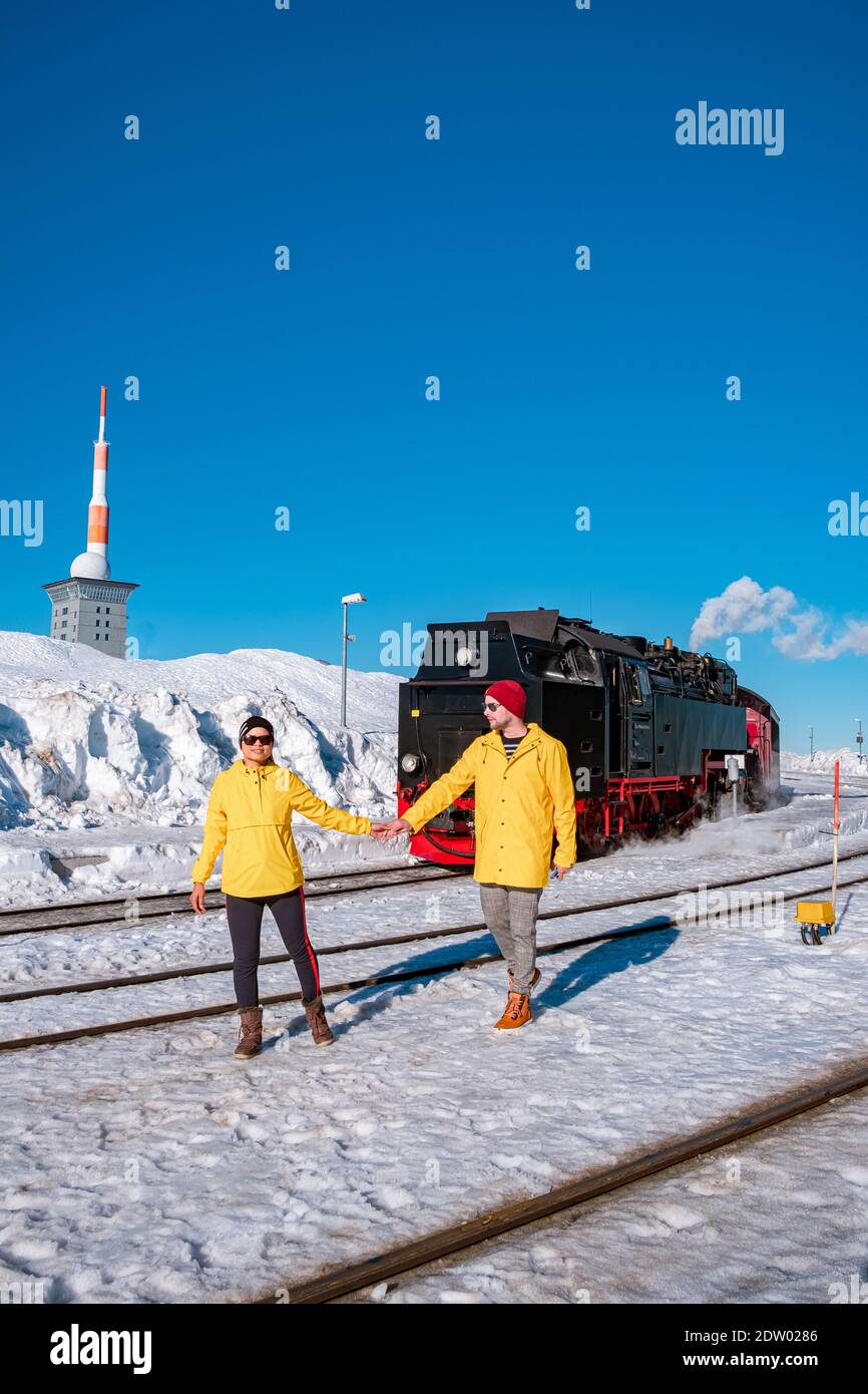 Paar Männer und Frauen wandern im Harz Nationalpark Deutschland, Dampfzug auf dem Weg nach Brocken durch die Winterlandschaft, berühmte Dampfzug durch den Winterberg. Brocken, Harz Deutschland Stockfoto
