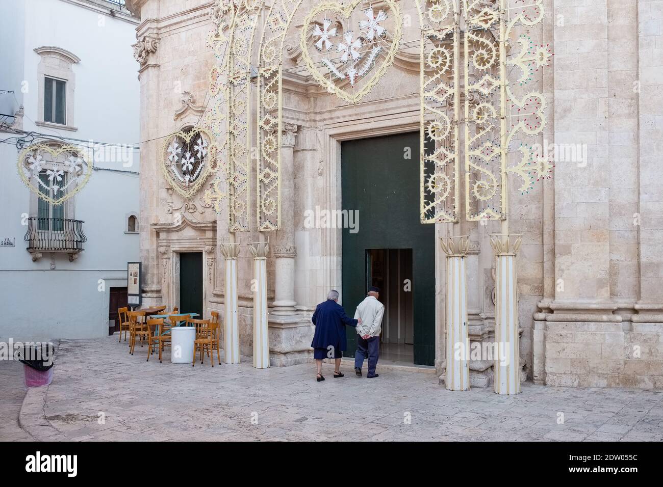 PUTIGNANO, ITALIEN - 12. OKTOBER 2019: Älteres Paar, das gemeinsam zur Kirche Santa Maria La Greca geht Stockfoto