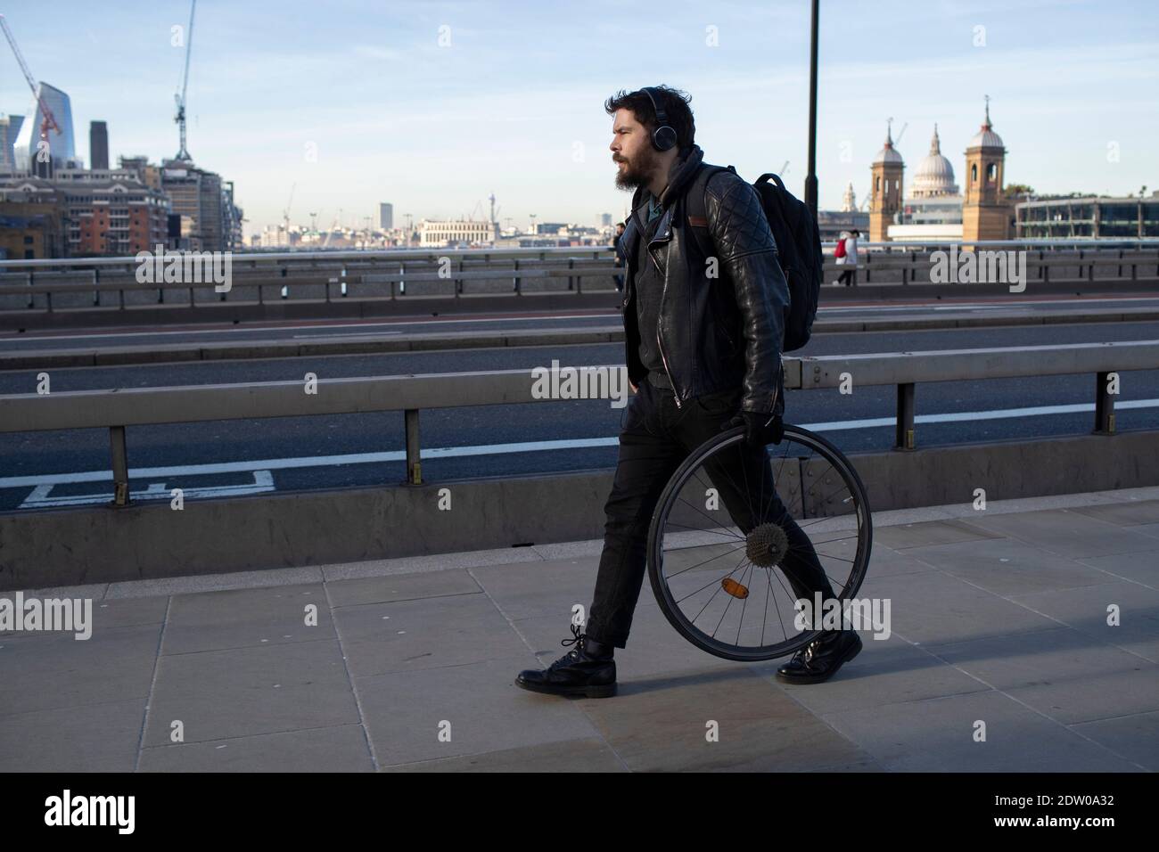 Ein Mann geht mit einem Fahrrad über die London Bridge Stockfoto