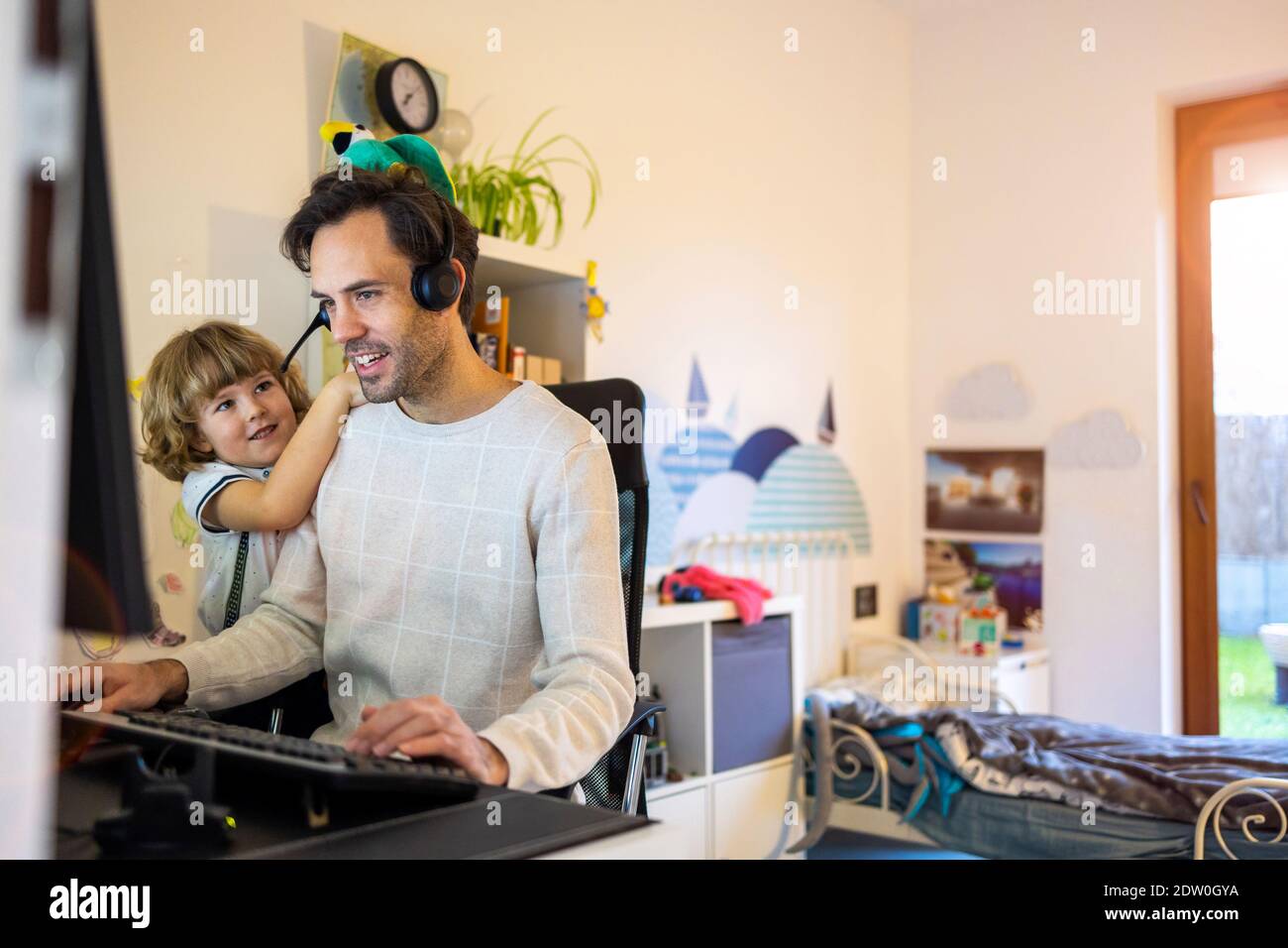 Vater versucht, von zu Hause aus mit seinen Kindern zu arbeiten Stockfoto