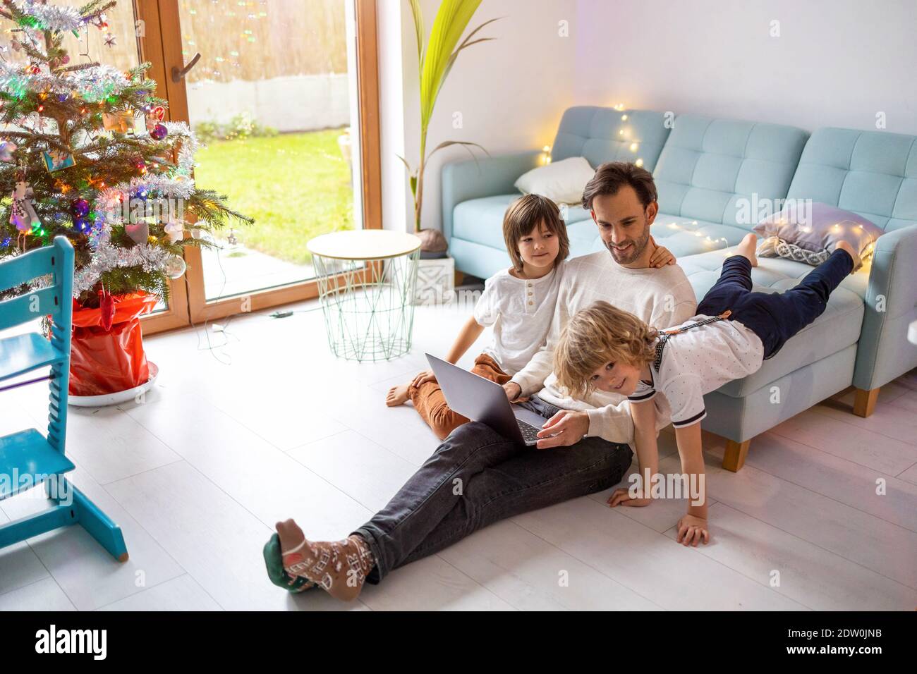 Vater versucht, von zu Hause aus mit seinen Kindern zu arbeiten Stockfoto