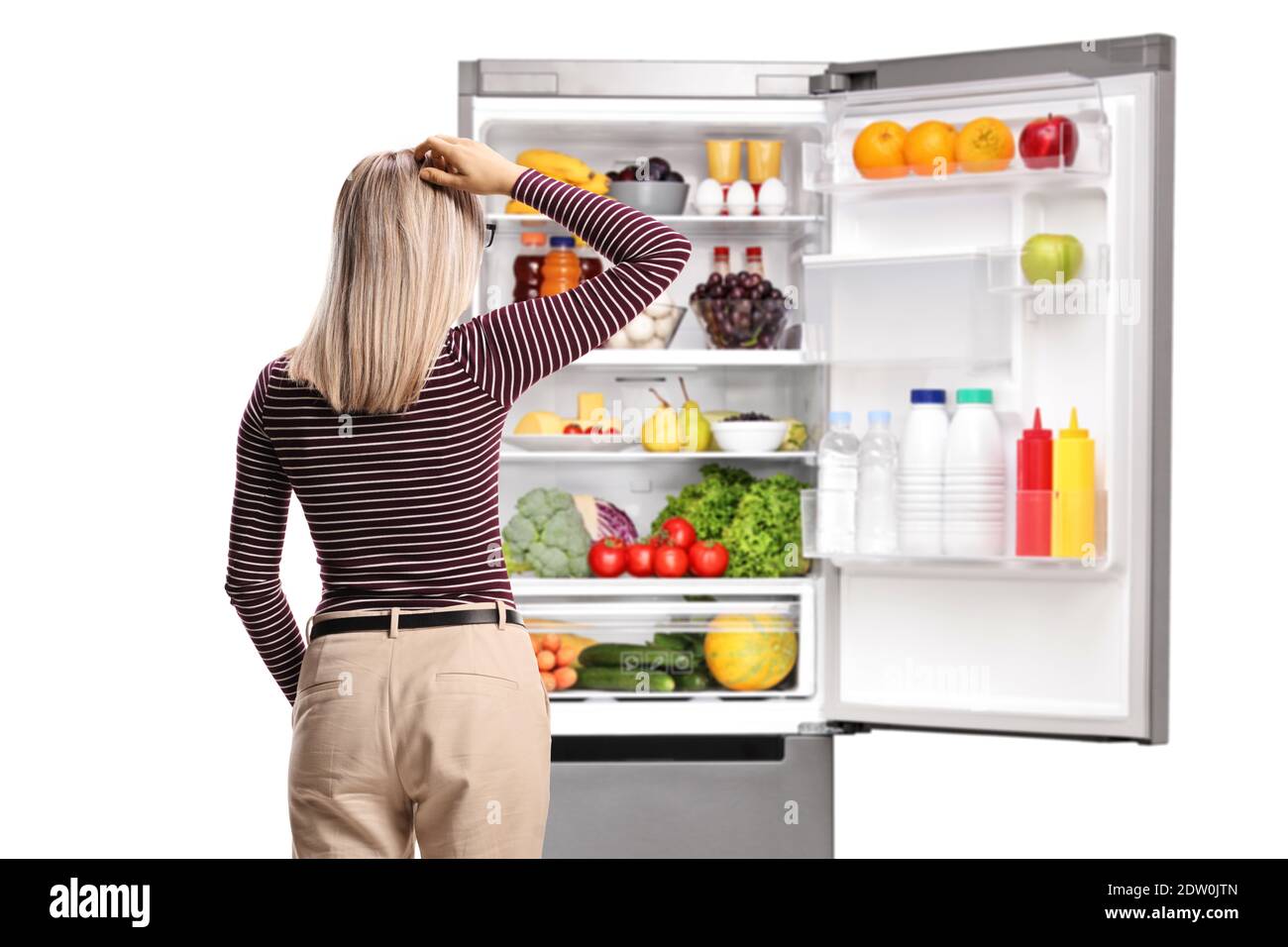 Rückansicht einer Frau, die vor einem steht Offener Kühlschrank mit einer Vielzahl von Lebensmitteln isoliert auf weißem Hintergrund Stockfoto