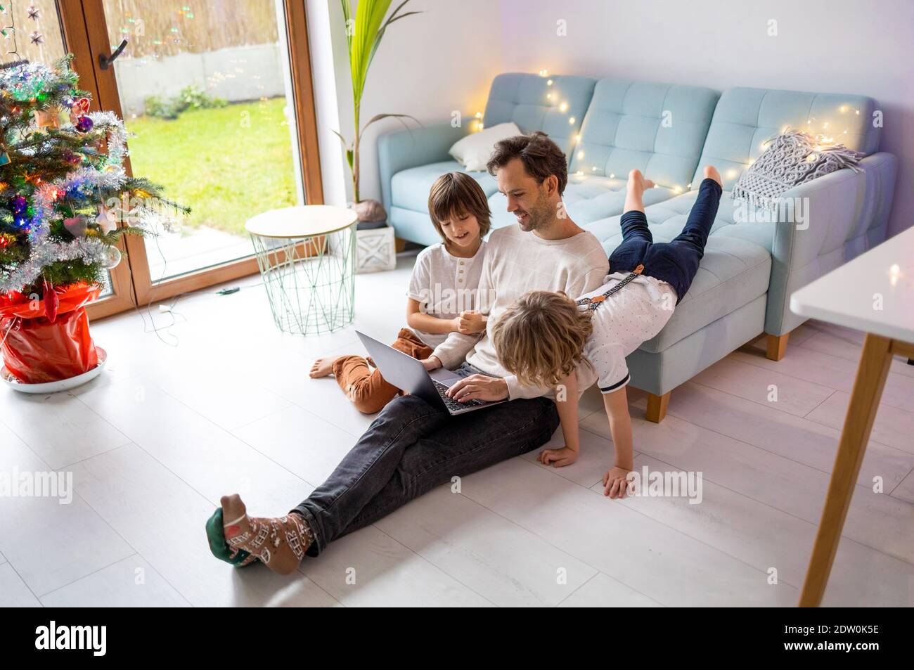 Vater versucht, von zu Hause aus mit seinen Kindern zu arbeiten Stockfoto