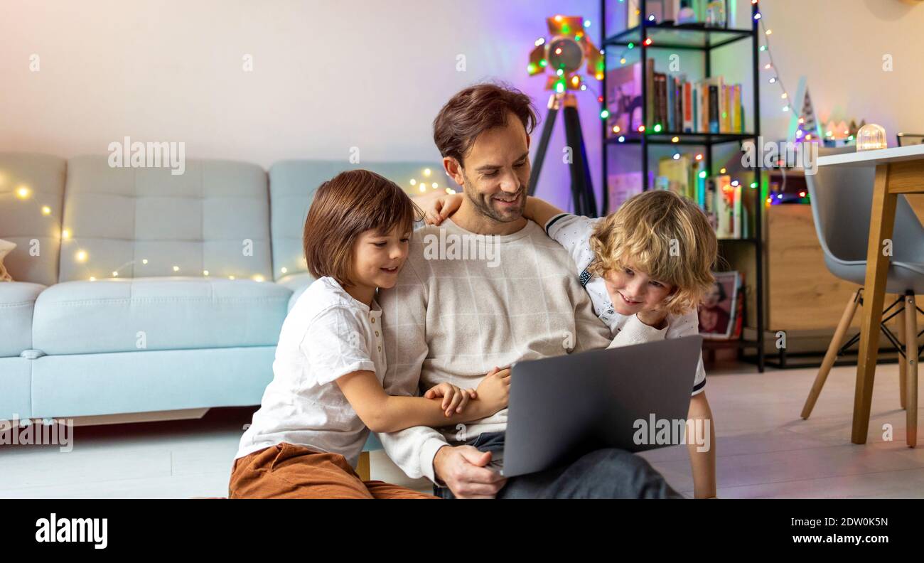 Vater versucht, von zu Hause aus mit seinen Kindern zu arbeiten Stockfoto