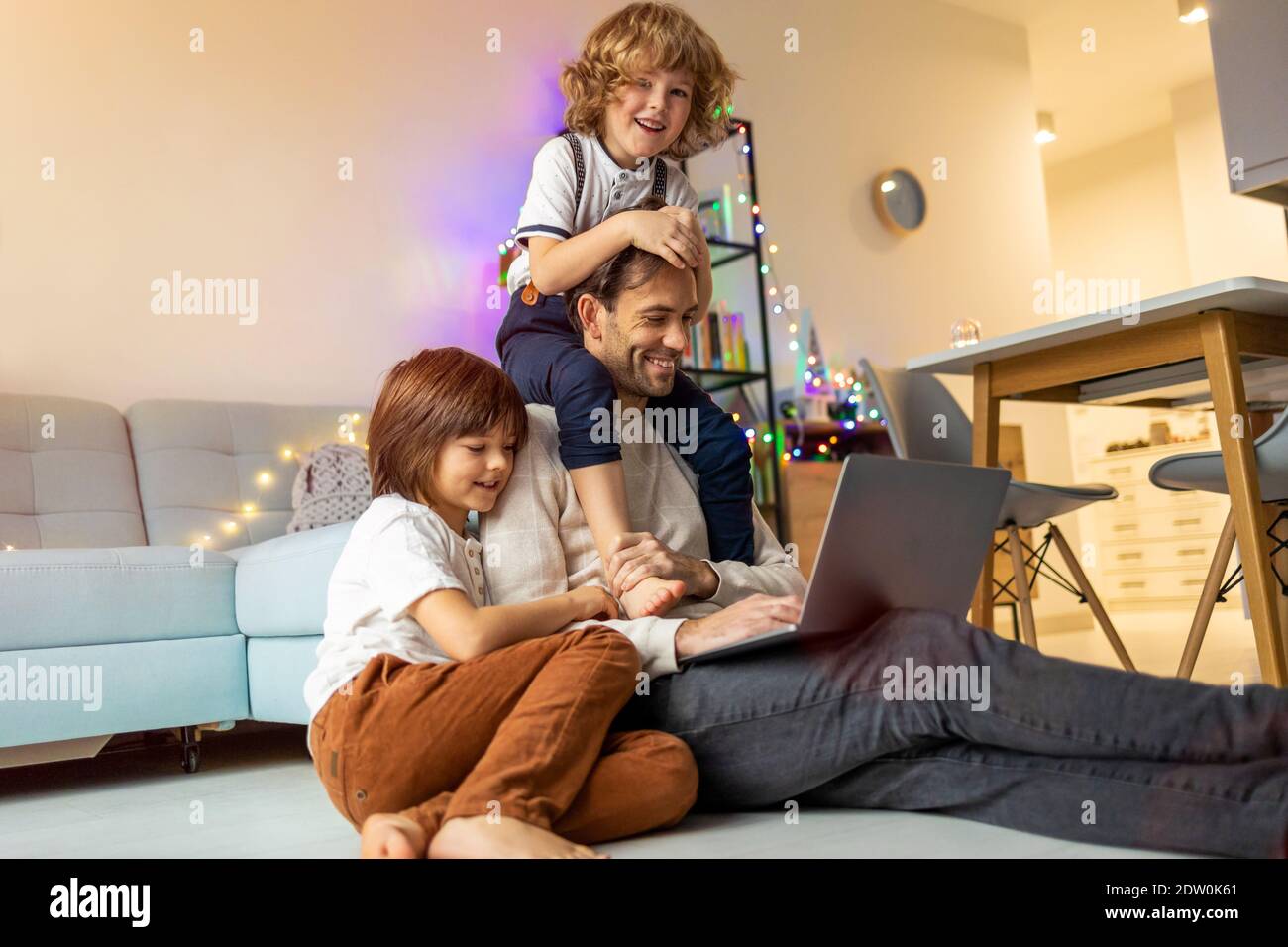 Vater versucht, von zu Hause aus mit seinen Kindern zu arbeiten Stockfoto