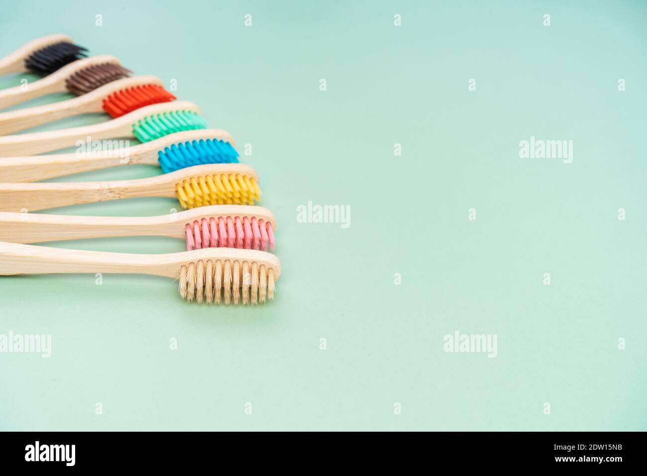 Ein Set umweltfreundlicher antibakterieller Zahnbürsten aus Bambusholz auf hellgrünem Hintergrund. Trends im Bereich Umweltschutz. Stockfoto
