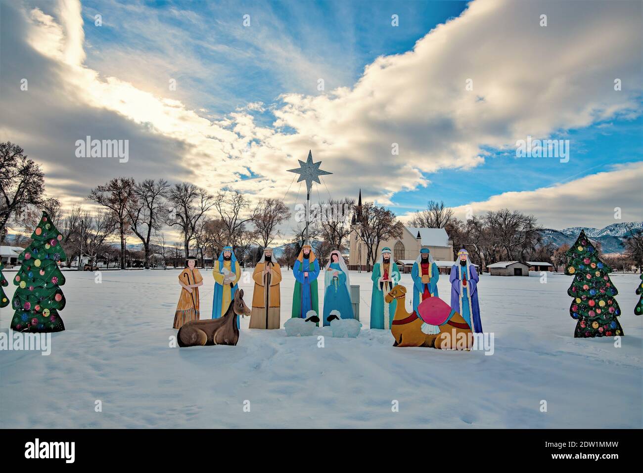 Wellsville, Utah, USA, 21. Dezember 2020. Hausgemachte Krippe zusammen mit weltlichen Dekorationen. Eine alte LDS Kirche im Hintergrund. Stockfoto