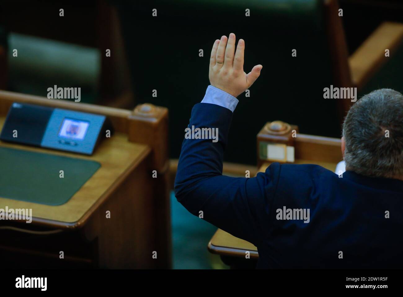 Bukarest, Rumänien - 22. Dezember 2020: Rumänische Senatoren stimmen in einer vollen Senatssitzung über Gesetzesentwürfe ab, indem sie ihre Hände heben. Stockfoto