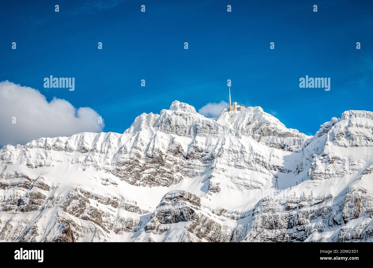 Hotel auf verschneiten Berggipfel mit blauem Himmel Stockfoto