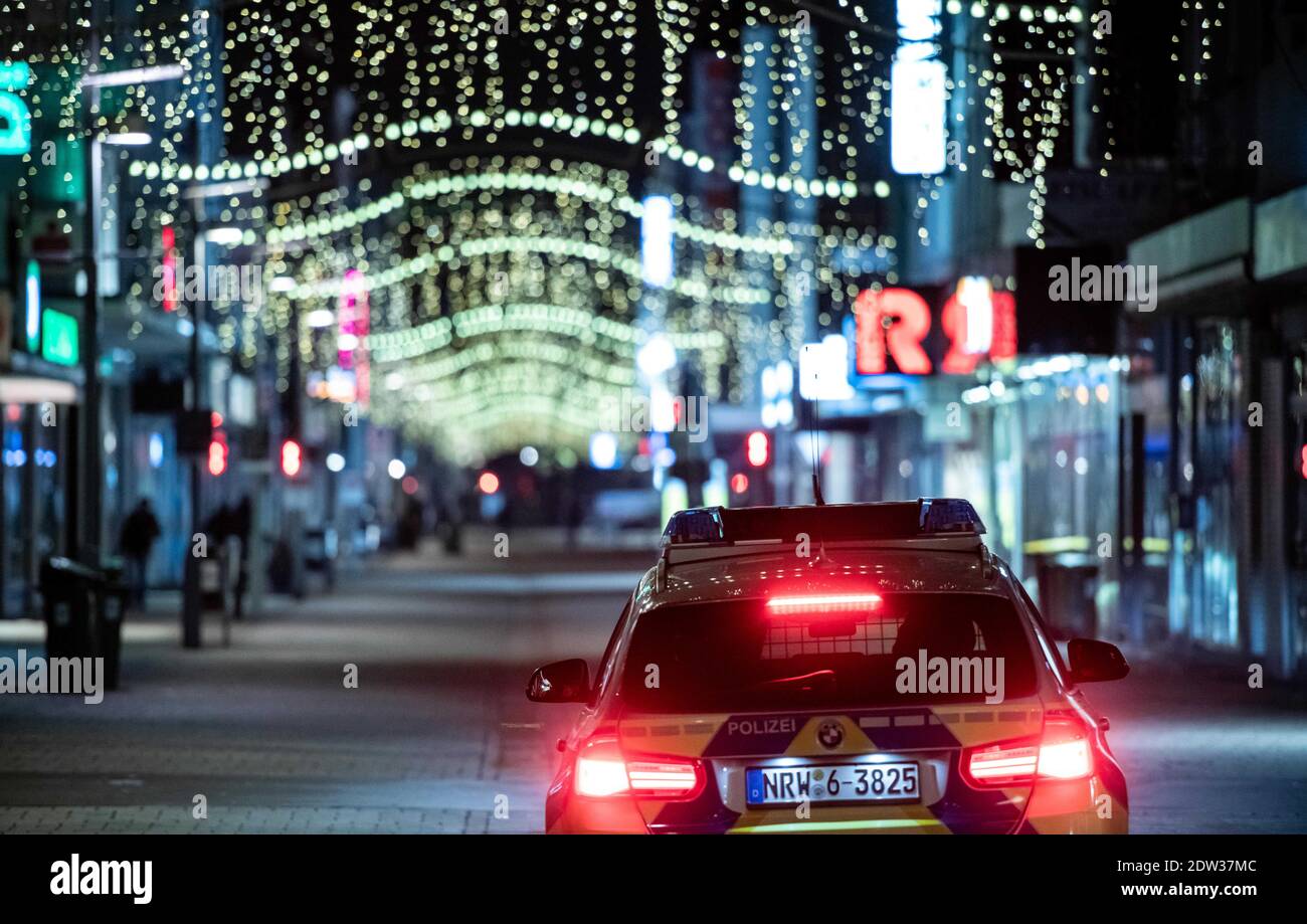 Oberhausen, Deutschland. Dezember 2020. Auf der Einkaufsstraße Marktstraße in der Innenstadt von Oberhausen gibt es kaum Passanten. Die Polizei kontrolliert zusammen mit dem Ordnungsamt auf der Straße. In Oberhausen gelten ab 22.12 verschärfte Sperrungen. 2020 aufgrund des Corona-Virus. Die Stadt hat sich für die Ausstiegsbeschränkung zwischen 21 und 5 Uhr entschieden. Quelle: Fabian Strauch/dpa/Alamy Live News Stockfoto