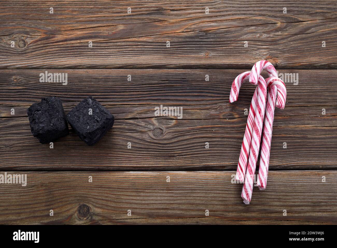 Weihnachtskohle für schlechte Kinder und Kerzen oder Geschenk für gute Kinder. Weihnachtstradition in vielen Ländern. Stockfoto