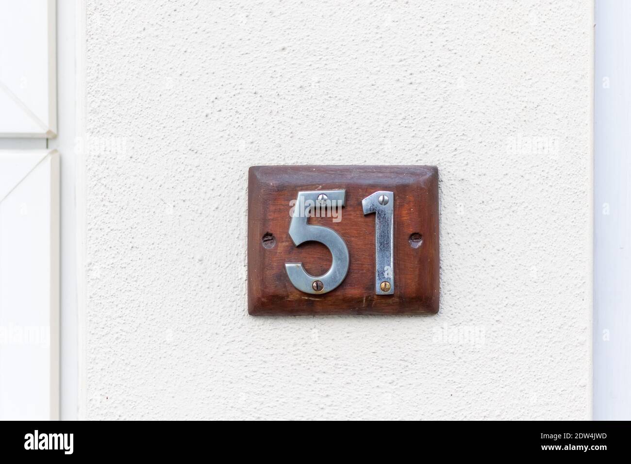 51 auf einer hölzernen Tafel an einer weißen Wand Stockfoto