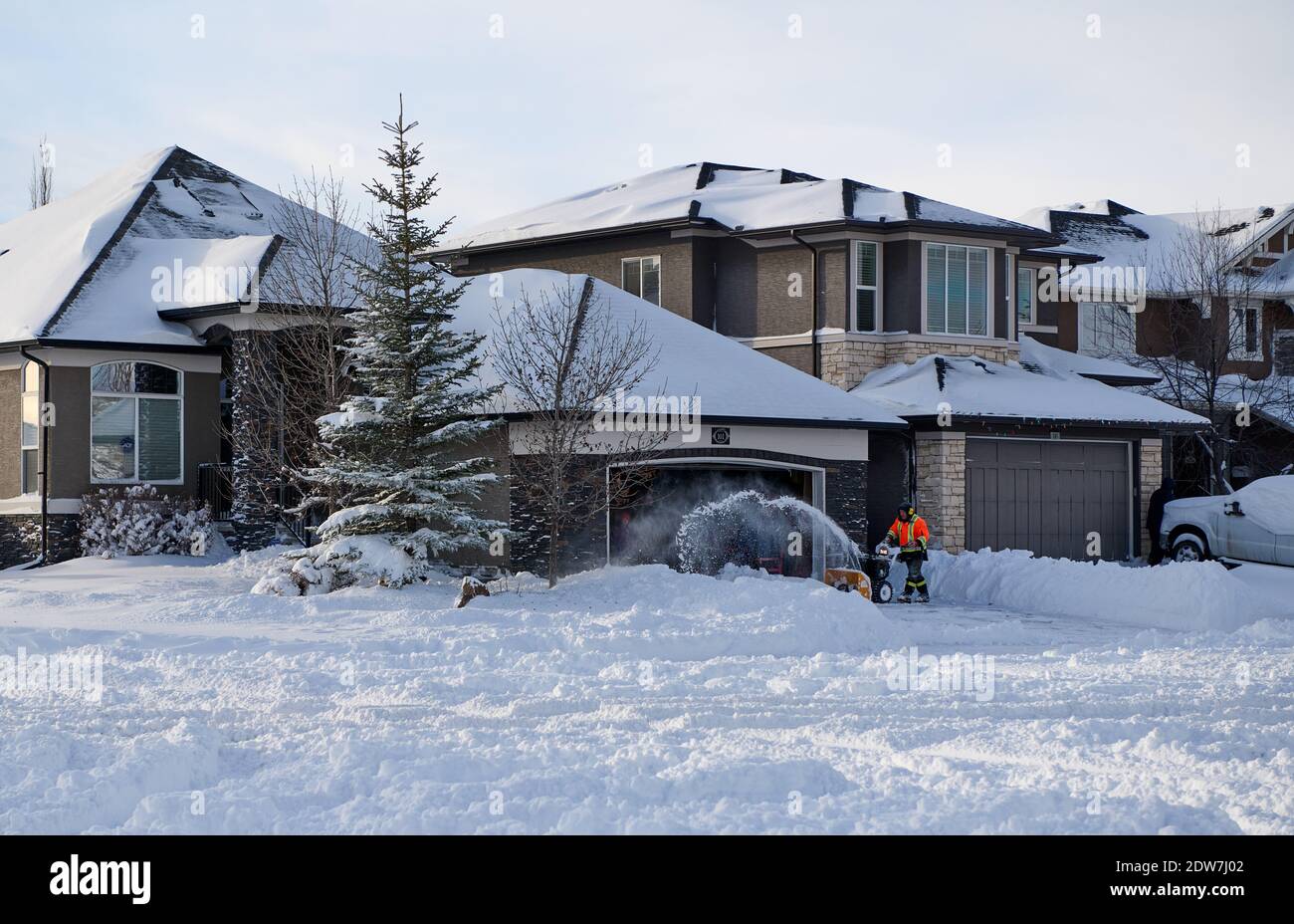 Person, die ein Schneegebläse verwendet, um die Fahrt nach 30 cm Schnee zu räumen, Calgary, Lake Chapala, Alberta, Kanada: 2020-12-22 Stockfoto