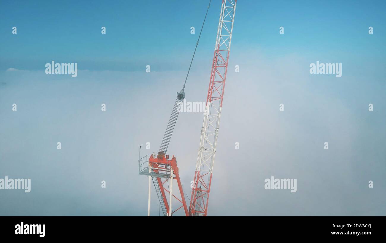 Sehr hoher Baukran im Morgennebel bedeckt. Hochwertige Fotos Stockfoto
