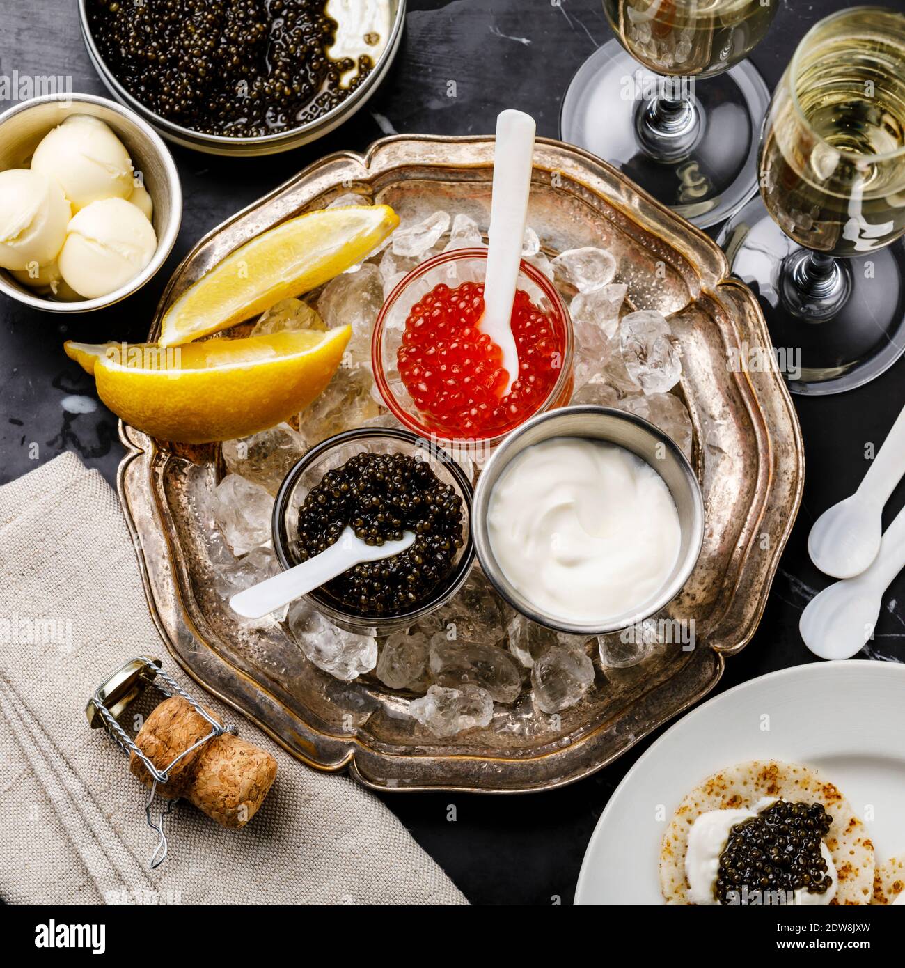 Rot und Schwarz Caviar, Mini Pancakes und Sour Cream Holiday Party Vorspeise auf dunklem Marmor Hintergrund Stockfoto