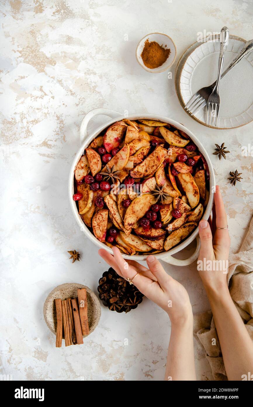 Gebackenen Apfel und Preiselbeere Dessert mit Händen halten die Schüssel. Stockfoto