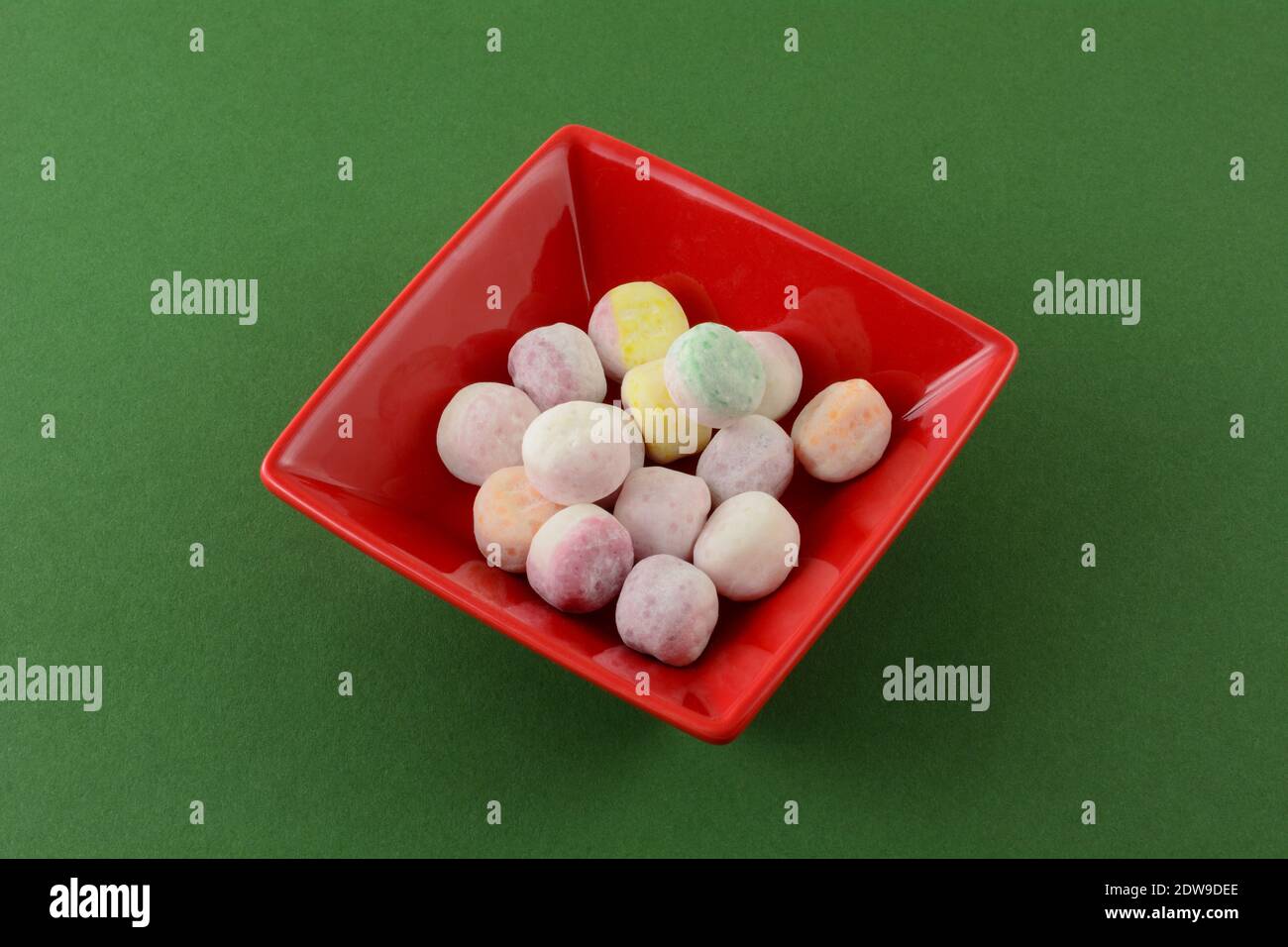 Verschiedene Mocktail Bonbon Süßigkeiten in roten Süßigkeiten Gericht auf grün Hintergrund Stockfoto