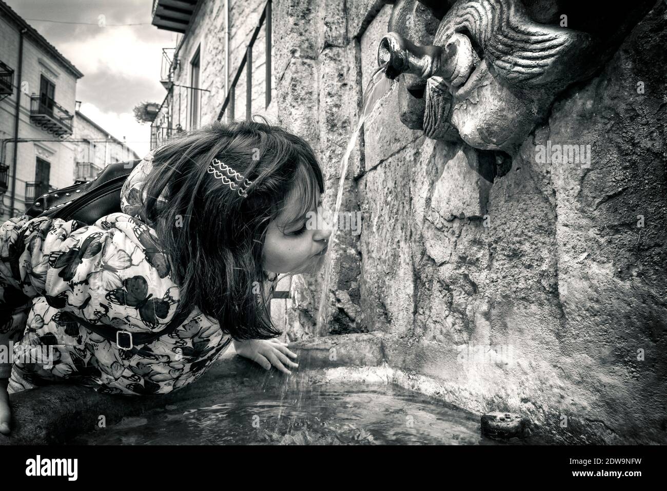 Mädchen Trinkwasser Aus Brunnen Stockfoto