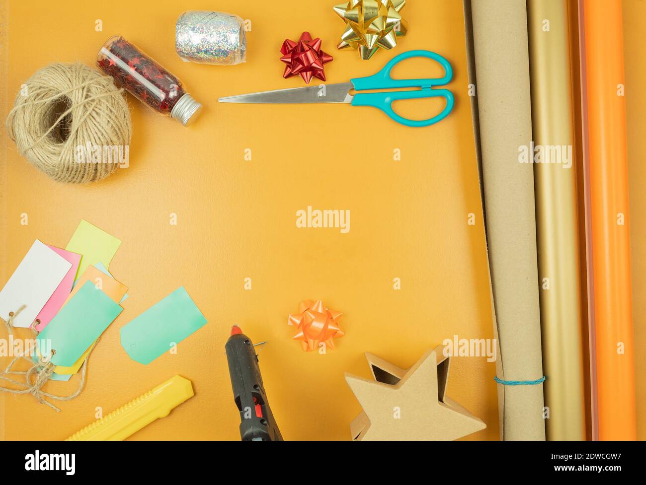 Geschenkverpackung mit Händen in Geschenkpapier auf dem Tisch als Hintergrund. Geburtstag oder Jubiläum Geschenke Einpacken in Geschenkpapier, Draufsicht Stockfoto