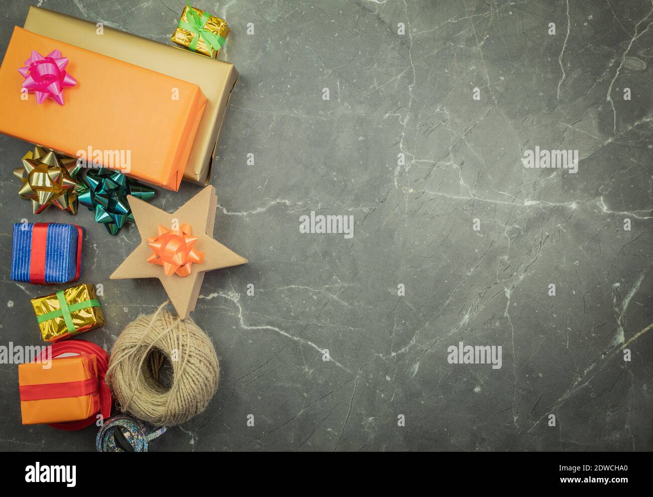 Geschenkverpackung mit Händen in Geschenkpapier auf dem Tisch als Hintergrund. Geburtstag oder Jubiläum Geschenke Einpacken in Geschenkpapier, Draufsicht Stockfoto