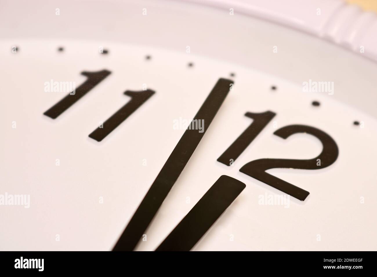 Zifferblatt einer analogen Uhr Nahaufnahme. Die Zeit ist 23:59 Uhr. Weißes  Zifferblatt, schwarze Ziffern. Sepia-getöntes Bild Stockfotografie - Alamy