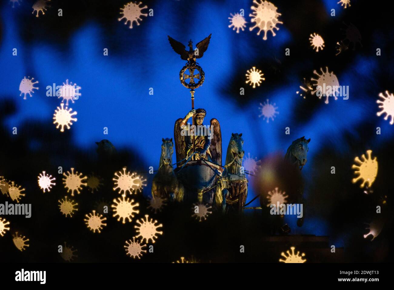 Berlin, Deutschland. Dezember 2020. Deutschland, Berlin, 22. Dezember 2020: DIESES BILD IST EIN SYMBOLFOTO. DAS FOTO WURDE MIT EINEM SPEZIELLEN AUSSCHNITTFILTER ERSTELLT UND ENTSPRICHT EXPLIZIT NICHT DEM TATSÄCHLICHEN ERSCHEINUNGSBILD VOR ORT. Die beleuchtete Quadriga am Brandenburger Tor ist hinter verschwommenen Lichterketten in Form eines abstrahierten Coronavirus auf einem Weihnachtsbaum am Pariser Platz zu sehen. Quelle: SIPA USA/Alamy Live News Stockfoto