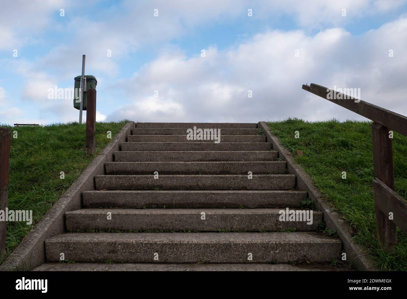 Betontreppe mit Holzgeländer blauen Himmel und weißen Wolken Stockfoto